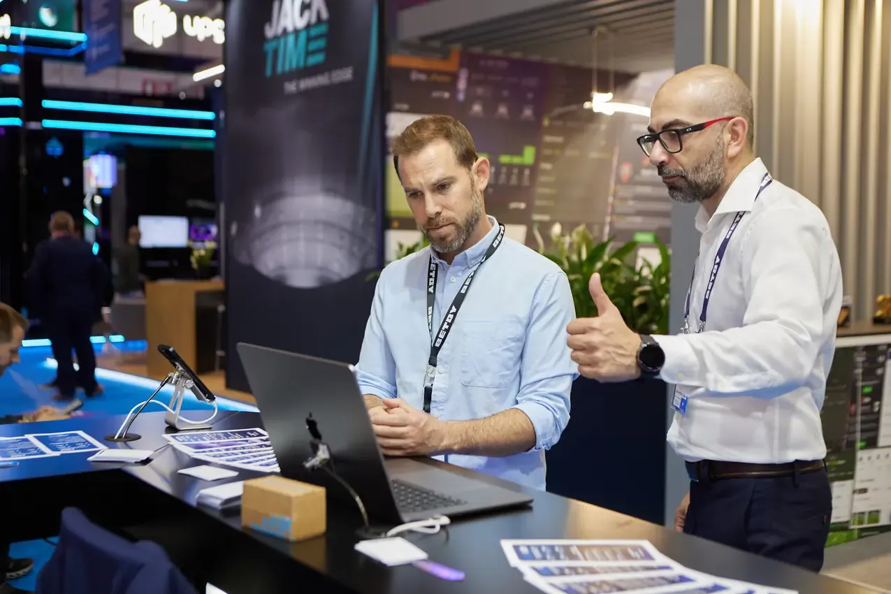Betby team member showing the platform to a visitor at SBC Summit 2024