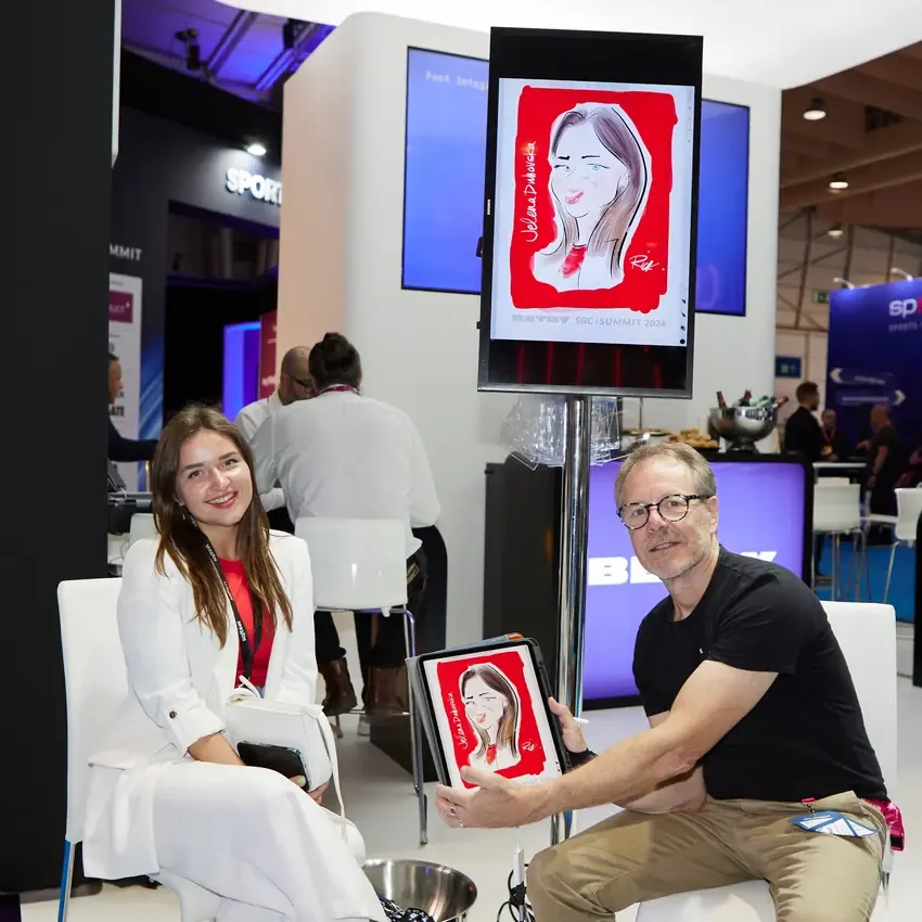Caricature artist drawing a visitor at the Betby stand, SBC Summit 2024