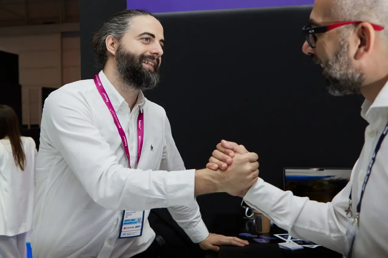 Handshake between two men at the Betby stand, SBC Summit 2024