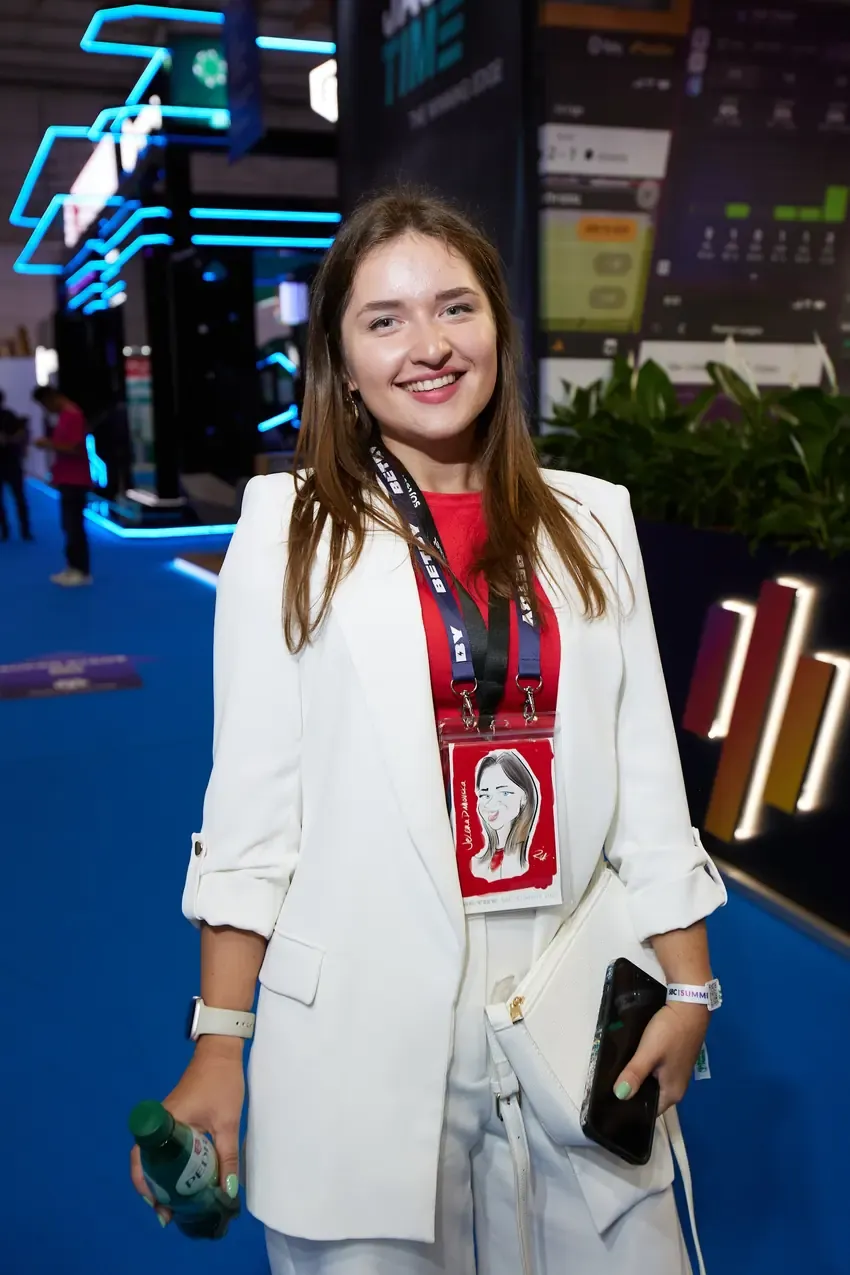 Visitor wearing her caricature badge at the Betby stand