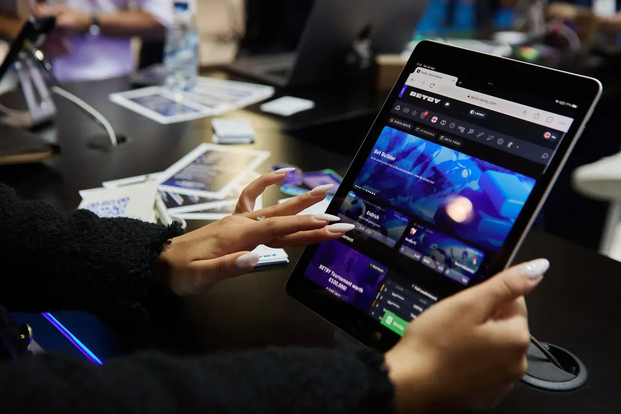 Visitor scrolling the Betby sportsbook on a tablet at SBC Summit 2024