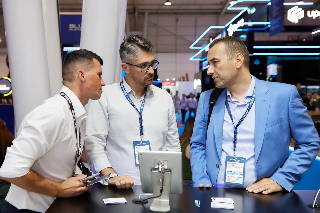 Three men reviewing the Betby platform at the stand