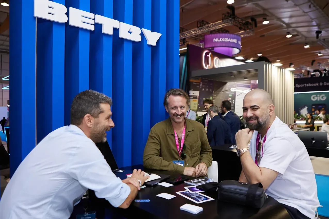 Betby team meeting three visitors at the stand table, SBC Summit 2024