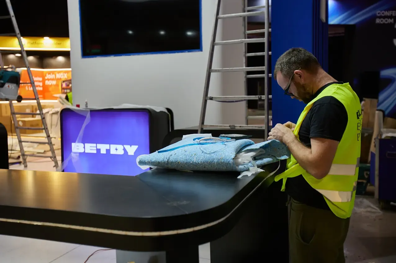 Contractor finishing the Betby counter at FIL before SBC Summit 2024 opens