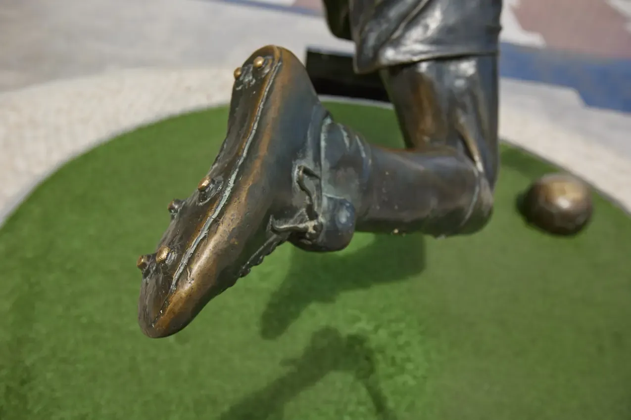 Close-up of the Eusébio statue and the bronze ball