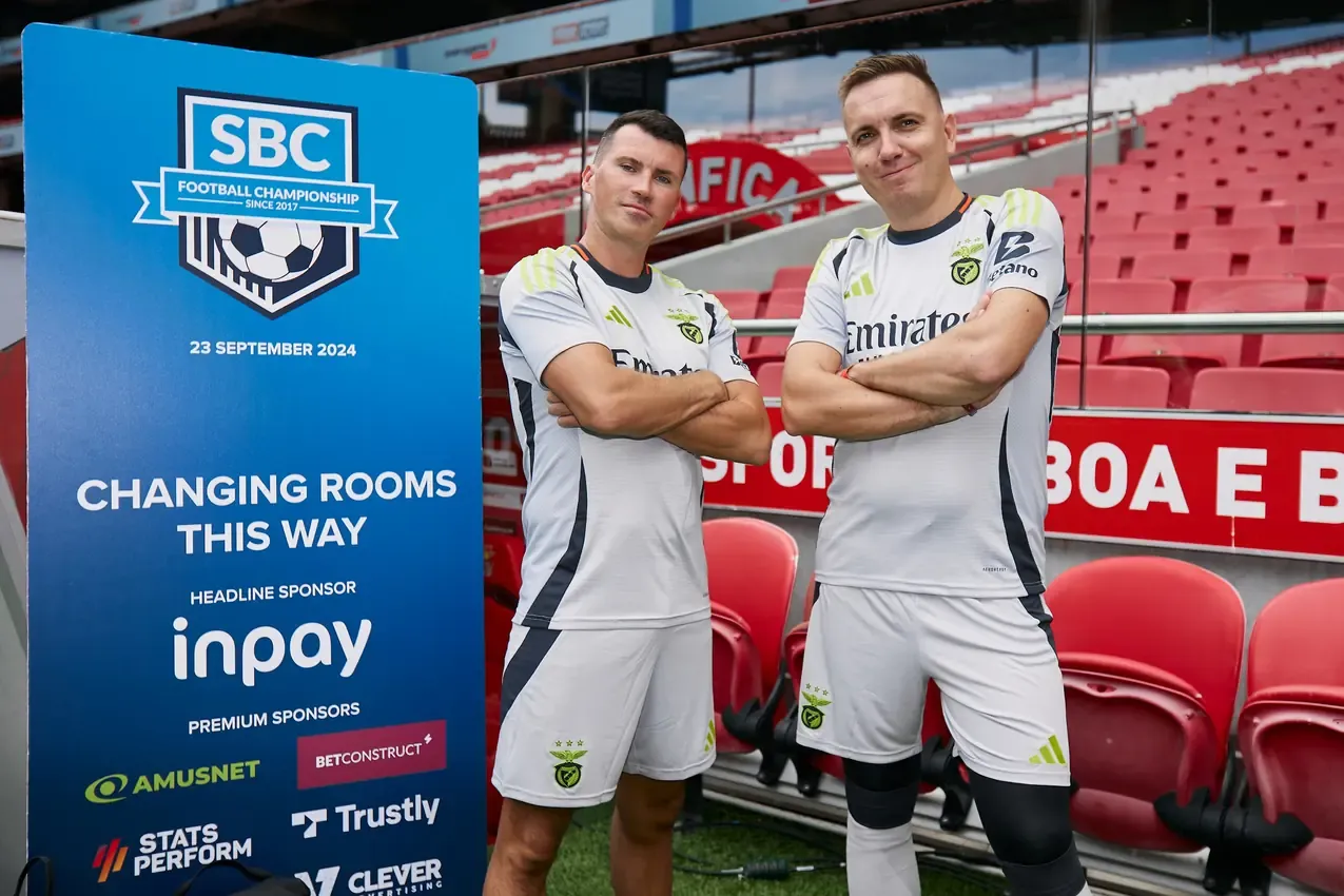 Two Betby players by the SBC Football Championship changing-room sign